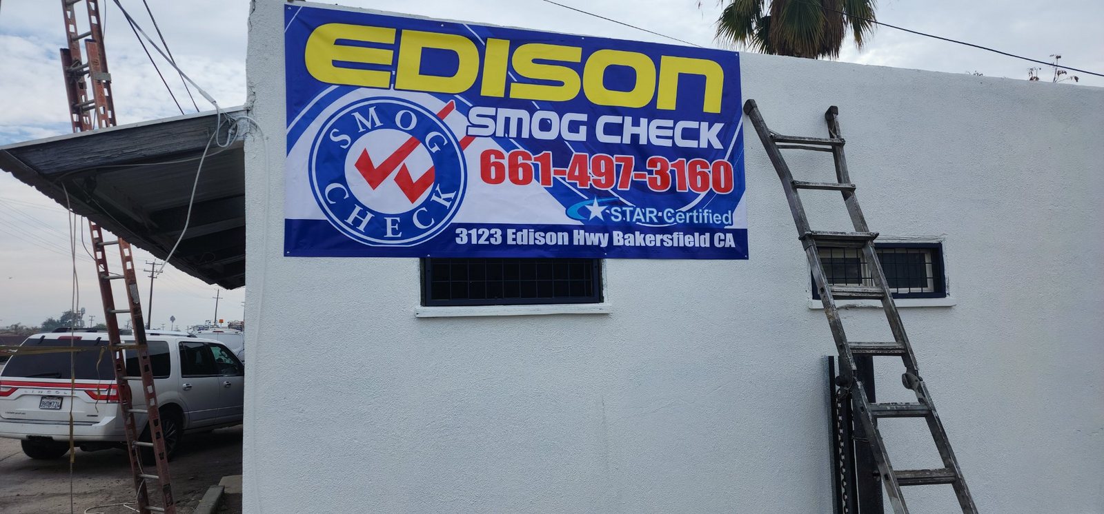 Banner de smog check instalado en la pared de un taller